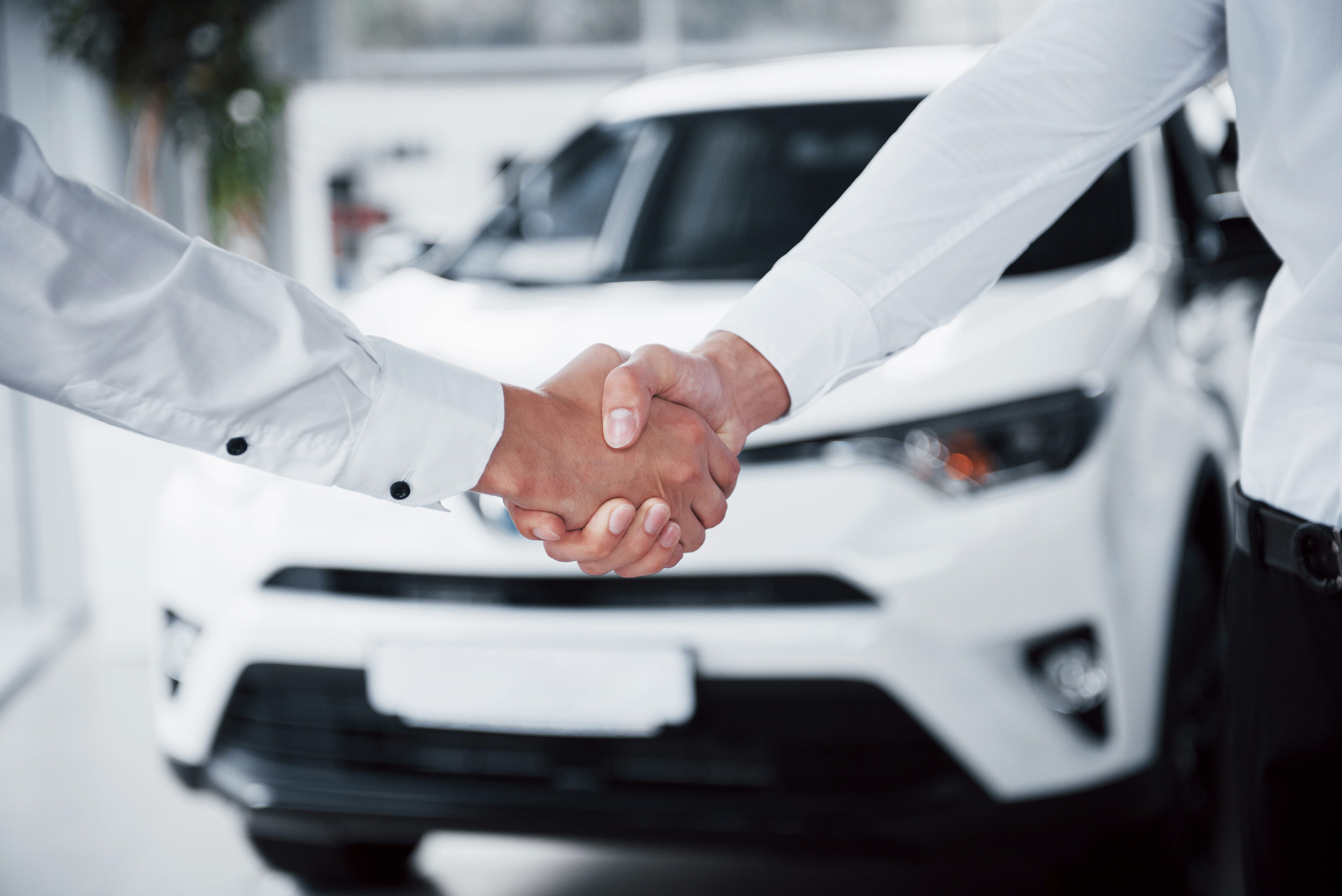 close_up_sales_manager_black_suit_selling_car_customer_1_c4758ed0a4.jpg